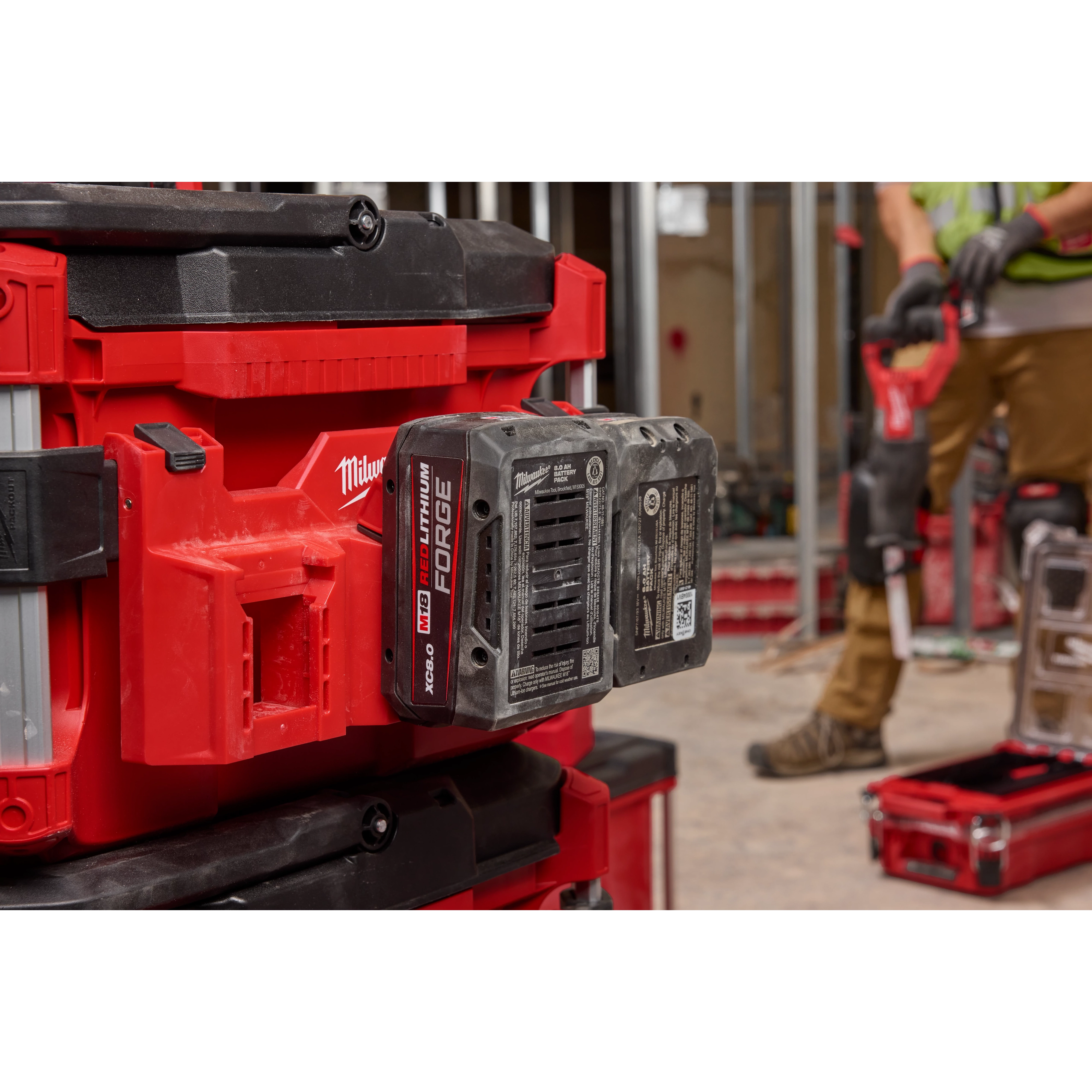 PACKOUT Tool Box M18 Battery Rack Attachment holding an M18 battery, attached to a red and black PACKOUT Tool Box system