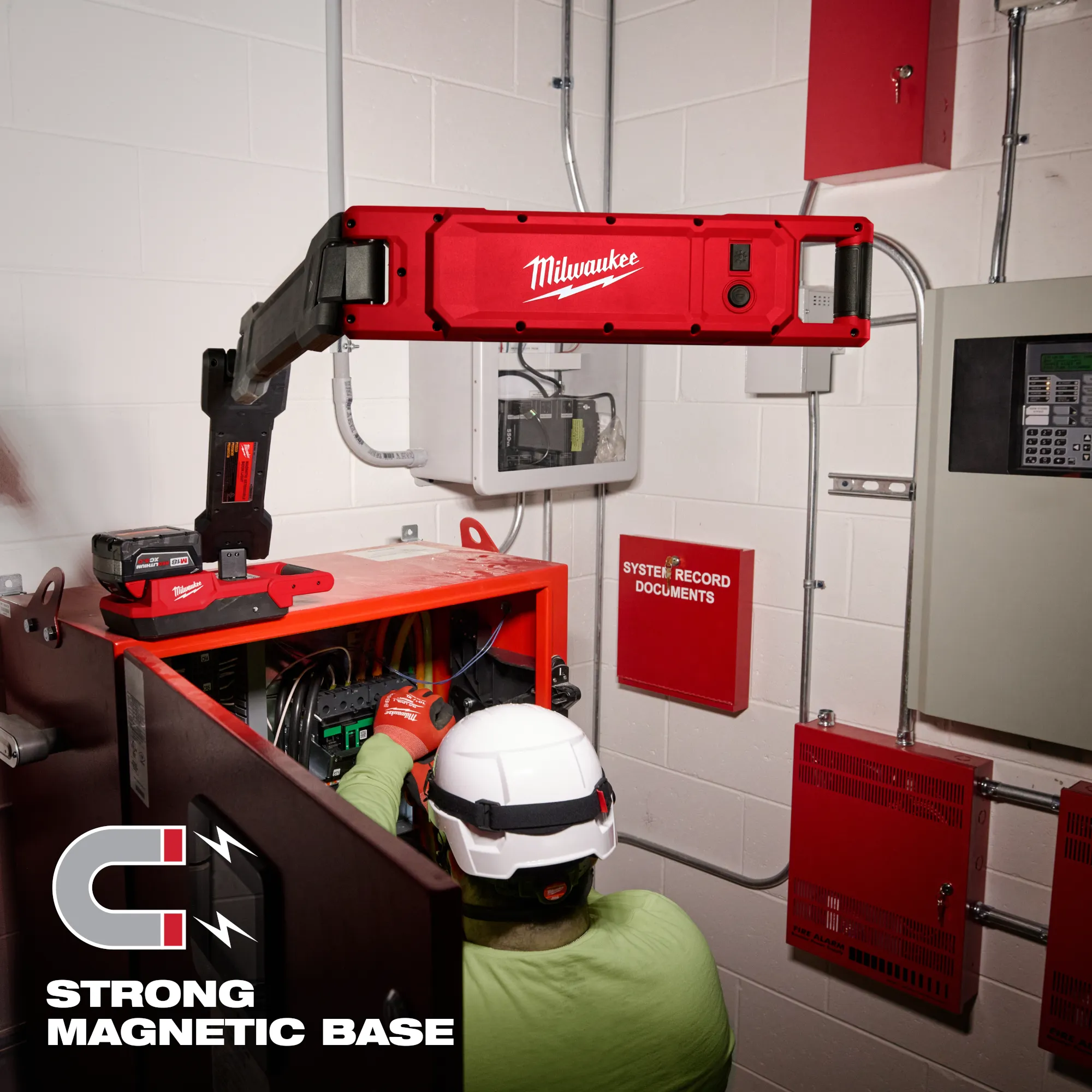 Image of a worker using the Milwaukee M18 Magnetic Extendable Boom Light on a jobsite with the text "Strong Magnetic Base"