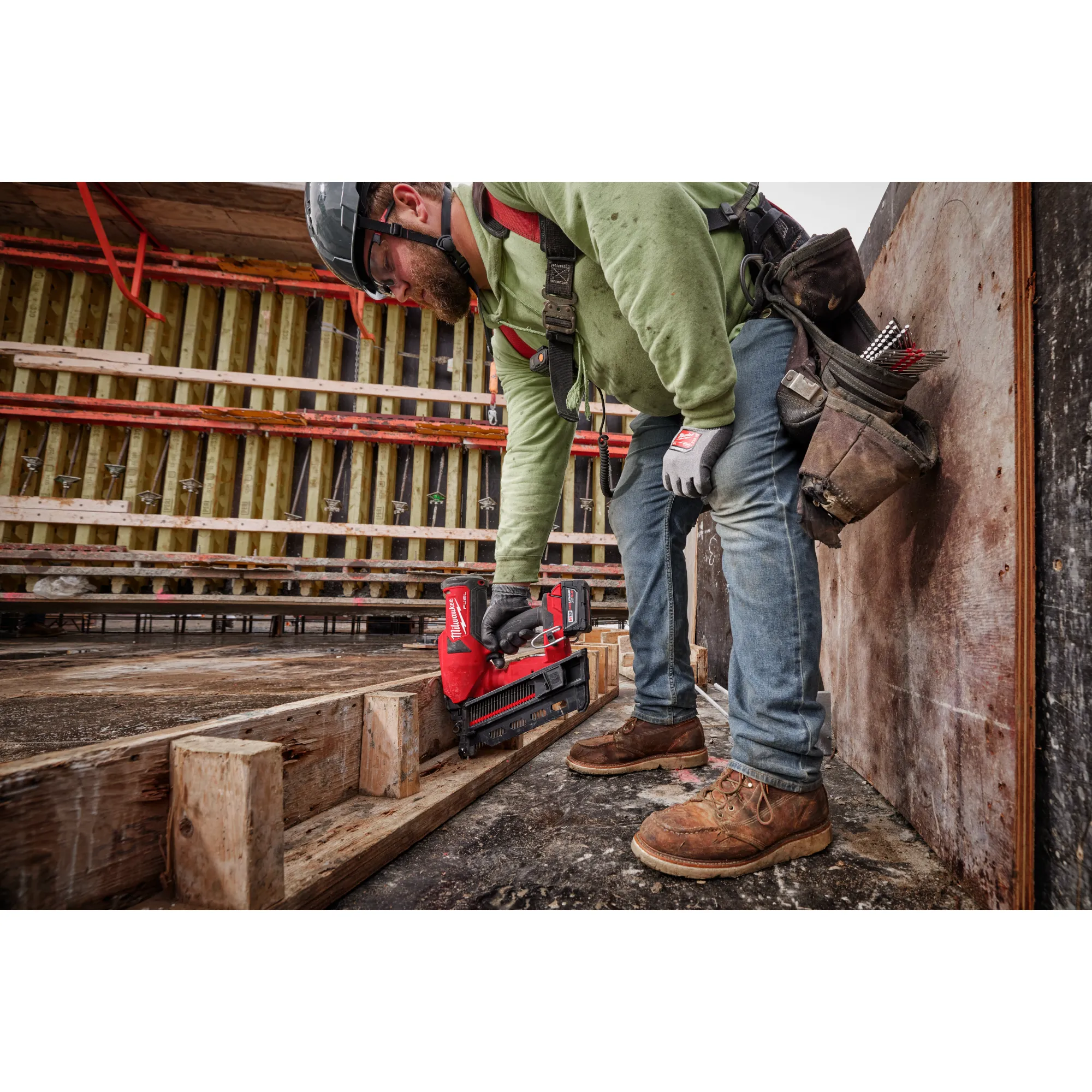 Image of  worker using the Milwaukee M18 Duplex Nailer to nail wood on a jobsite